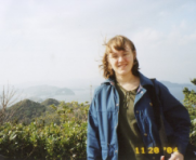 A picture of me standing on Awaji Island, Japan on a windy day with my backpack and blue jacket.